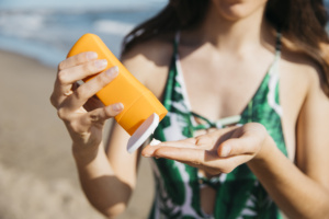 Femme appliquant de la crème solaire sur la plage
