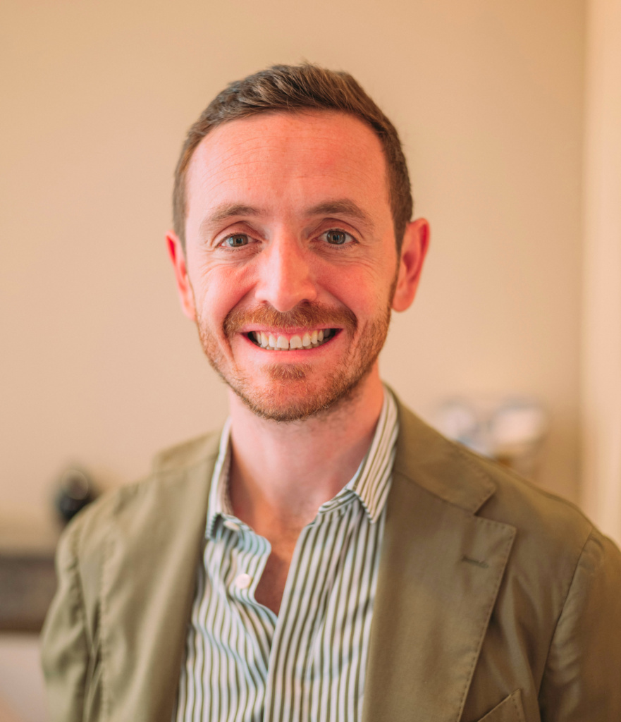 Homme souriant en veste verte.